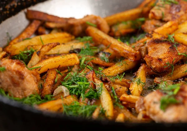 stock image Fried Meat with fried halves of potatoes in a skillet