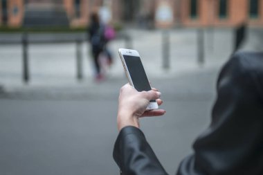 Kadın sokakta telefon tutarak. Cep telefonu ile yakın çekim kadının el