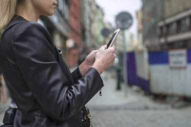 Kadın sokakta telefon tutarak. Cep telefonu ile kadının el