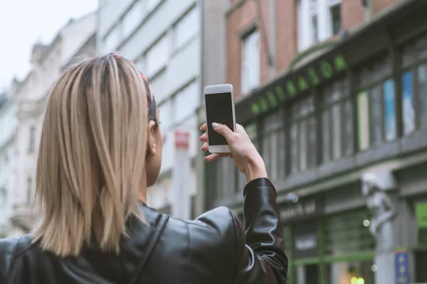 stock image Woman tourist taking picture with mobile camera in the street