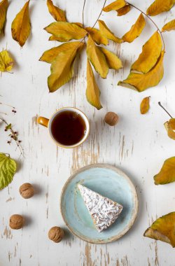 Kurumuş yapraklı ve cevizli sıcak çayla servis edilen fırında turta, sonbahar kompozisyonu.
