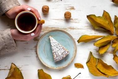 Kurutulmuş yaprak ve cevizli sıcak çayla servis edilen fırında turta.