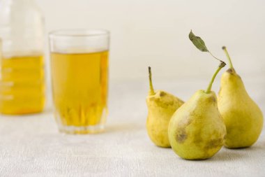 Beyaz ahşap arka planda bir bardakta armut suyu.