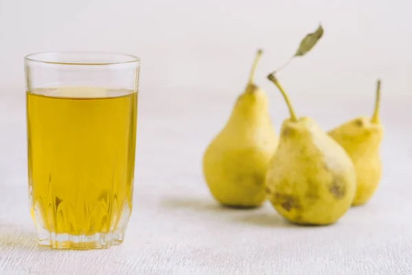 stock image Juice of pears  in a glass on a white wooden background