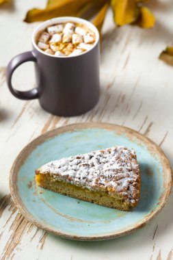 Pasta, ceviz ve saçılmış yapraklarla, sonbahar kompozisyonu eşliğinde eski püskü bir masada lokum tutan kadınların üst görüntüsü.