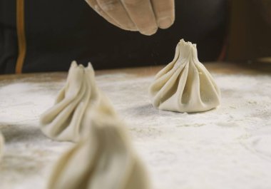 Aşçı ahşap masada khinkali yapıyor. İşlem hazırlığı Gürcistan yemeği. yiyecek konsepti.