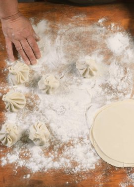 Aşçı ahşap masada khinkali yapıyor. İşlem hazırlığı Gürcistan yemeği. yiyecek konsepti.