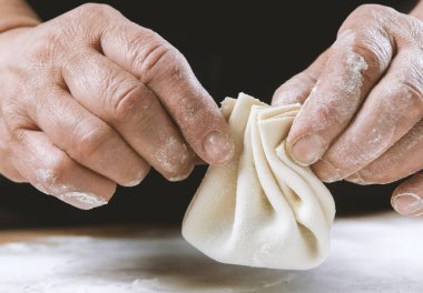 Aşçı ahşap masada khinkali yapıyor. İşlem hazırlığı Gürcistan yemeği. yiyecek konsepti.