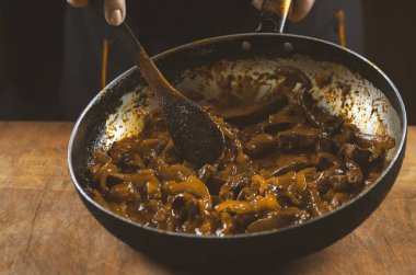 Aşçı eti sebzeli ve soğanlı bir kasede hazırlar. Doğu mutfağı.