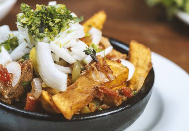 Beef stew with potatoes, carrots and herbs on black background with copy