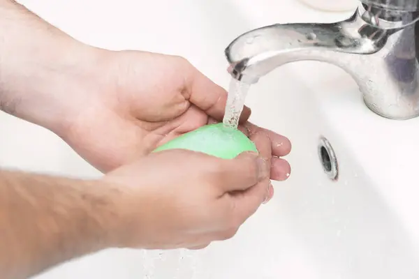 A man washes  hands with soap in the bathroom. The best defense against viral infection of the crown. Protection against a coronary virus pandemic by frequent hand cleaning.