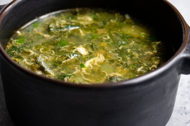 Siyah seramik kapta gri arka planda yeşil doru çorba.