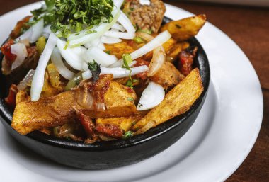 Beef stew with potatoes, carrots and herbs on black background with copy