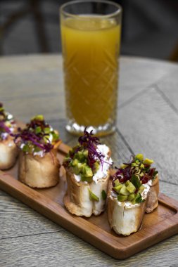 Avokadolu kanepeler, ahşap tahtada mozarella peyniri ve sos. bruschetta.