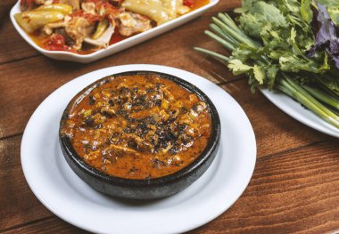 Tahta masadaki siyah kasede domuz etli Tayland baharatlı biber sosu