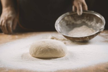 Hamur yoğurma fırını. Aşçı ahşap masada turta pişirmek için hamur yapıyor. İşlem hazırlığı ev yapımı hamur işi. Makarna, ekmek, spagetti, khachapuri, yemek konsepti.