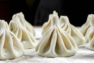 Aşçı ahşap masada khinkali yapıyor. İşlem hazırlığı Gürcistan yemeği. yiyecek konsepti.