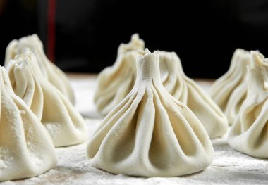 Aşçı ahşap masada khinkali yapıyor. İşlem hazırlığı Gürcistan yemeği. yiyecek konsepti.