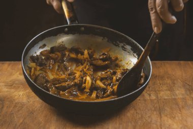 Aşçı eti sebzeli ve soğanlı bir kasede hazırlar. Doğu mutfağı.