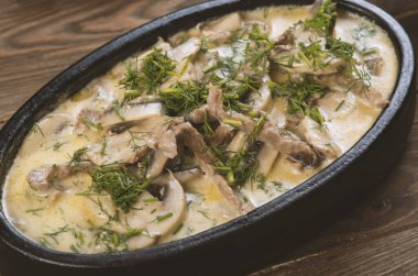 Tavada servis edilen kremalı sosta sığır eti ve mantar güveci.