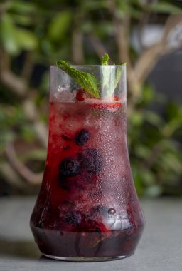 Refreshing summer drink with berries and mint in a glass. lemonade