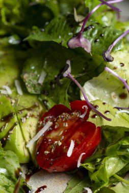 Fresh green salad with cherry tomatoes, arugula and olive oil