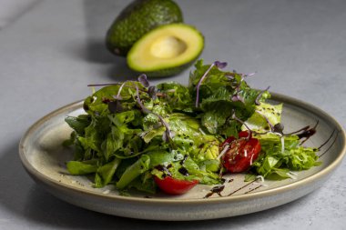 Fresh green salad with cherry tomatoes, arugula and olive oil