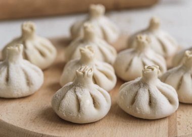 Ahşap masada çiğ donmuş khinkali. İşlem hazırlığı Gürcistan yemeği. yiyecek konsepti.