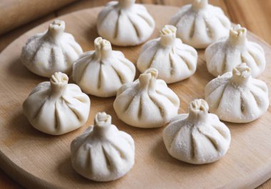 Ahşap masada çiğ donmuş khinkali. İşlem hazırlığı Gürcistan yemeği. yiyecek konsepti.