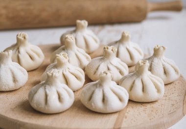 Ahşap masada çiğ donmuş khinkali. İşlem hazırlığı Gürcistan yemeği. yiyecek konsepti.