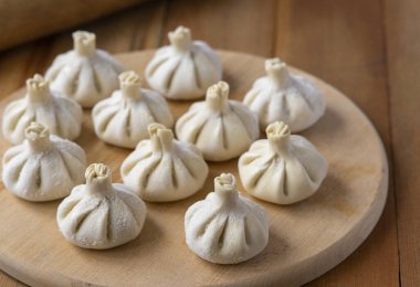 Ahşap masada çiğ donmuş khinkali. İşlem hazırlığı Gürcistan yemeği. yiyecek konsepti.