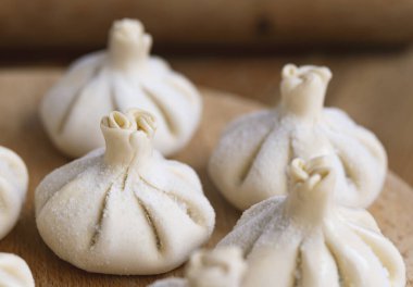 Ahşap masada çiğ donmuş khinkali. İşlem hazırlığı Gürcistan yemeği. yiyecek konsepti.