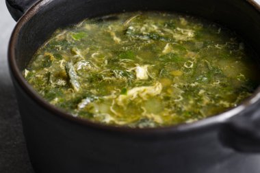 Siyah seramik kapta gri arka planda yeşil doru çorba.