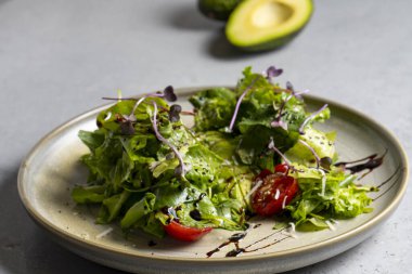 Fresh green salad with cherry tomatoes, arugula and olive oil