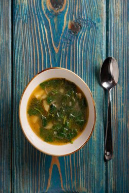 Mavi ahşap arka planda ıspanaklı çorba..