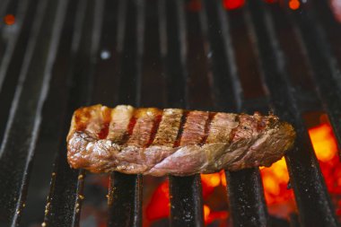 Alevli ızgarada ızgara biftekler seçici bir odak ile vurulacak.