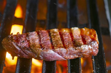 Alevli ızgarada ızgara biftekler seçici bir odak ile vurulacak.