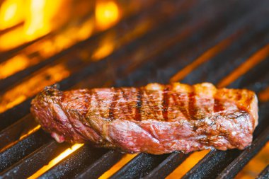 Izgarada alevler içinde biftek cızırdıyor.