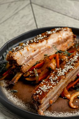 Ahşap bir tabakta sebzeli domuz pirzolası.