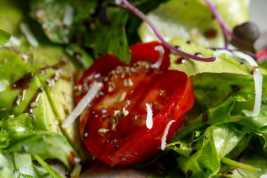 Fresh green salad with cherry tomatoes, arugula and olive oil