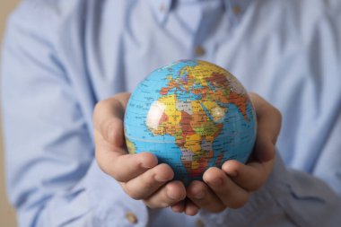 Elinde bir küre tutan adamın yakın çekimi. Bireyin gezegenin refahı için bakımı kavramı.