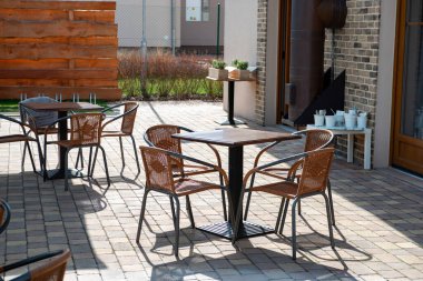 Özel bir evin avlusunda masa ve sandalyeler. İçeride kimse yok.