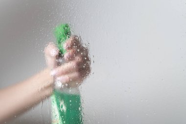 bir sprey şişesi ile cam temizler