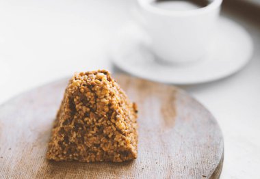 Bir fincan kahve ve tahtanın üzerinde bir parça kek.