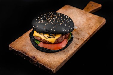 Ahşap masadaki lezzetli siyah burger..