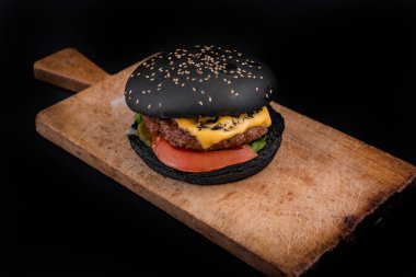 Ahşap masadaki lezzetli siyah burger..