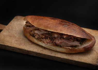 Shawarma ve sarımsak ahşap masada, siyah arka planda.