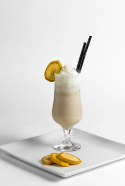 Muzlu milkshake, beyaz bir tabakta muz parçalarıyla birlikte dondurmalı dondurma..