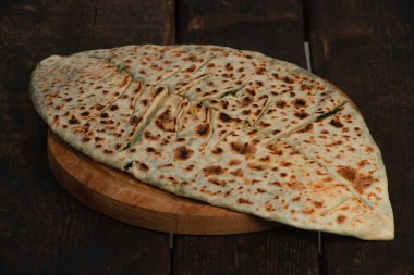 Ahşap tahtada otlu ve peynirli geleneksel turta.