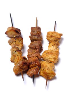 Beyaz arka planda şiş kebapların leziz görüntüsü